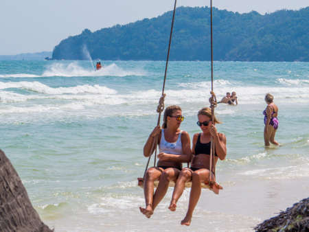 PHU QUOC, VIETNAM - FEBRUARY 7, 2018:Girls having fun on a swing on the popular Sao Beach (Vietnamese: Bai Sao).のeditorial素材