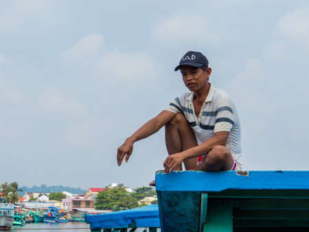 PHU QUOC, VIETNAM - FEBRUARY 8, 2018: Fisherman on the top of a boat in Duong Dong port.のeditorial素材