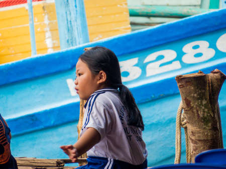 PHU QUOC, VIETNAM - FEBRUARY 8, 2018: Local girl sitting on the piar of the Duong Dong port.