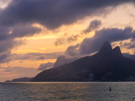 View of the Two Brothers Hill and the Vidigal favela as seen from Ipanema Beach at sunset. In Rio de...