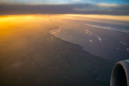 Landscape, sunrise and turbine seen from the airplane window