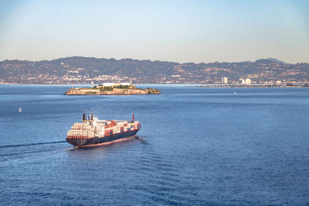Container Cargo Ship entering San Francisco Bay and Alcatraz Island - San Francisco, California, USAの写真素材