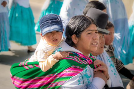 Traditional Woman (Cholita) in Typical Clothes with baby on her back During 1st of May Labor Day Parade - La Paz, Boliviaのeditorial素材