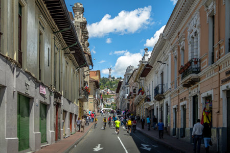 Bikers and pedestrians on a sunday closed street of Quito and Monument to the Virgin Mary on the top of El Panecillo Hill - Quito, Ecuadorのeditorial素材