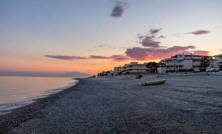 Sunset on a Mediterranean beach of Ionian Sea with Mount Etna Volcano on background - Bova Marina, Calabria, Italyの写真素材