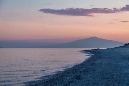 Sunset on a Mediterranean beach of Ionian Sea with Mount Etna Volcano on background - Bova Marina, Calabria, Italyの写真素材