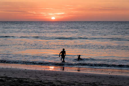 Man and dog silhouette at Beautiful sunset in Mancora Beach - Mancora, Peruの写真素材