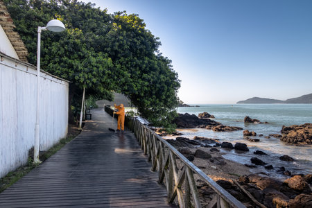 Janitor sweeping a wooden walkay - Balneario Camboriu, Santa Catarina, Brazilのeditorial素材