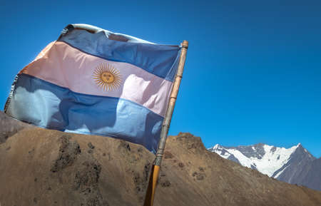 Argentina flag with Nevado Juncal Mountain on background in Cordillera de Los Andes - Mendoza Province, Argentinaの写真素材