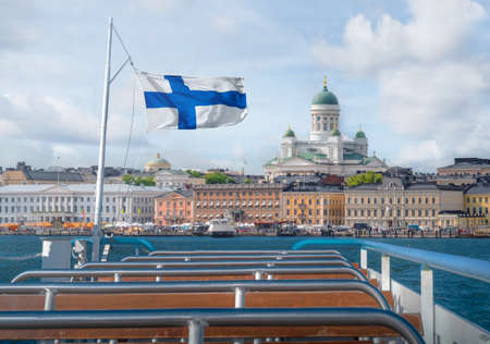 Helsinki skyline boat view with Finnish flag and Helsinki Cathedral - Helsinki, Finlandの写真素材