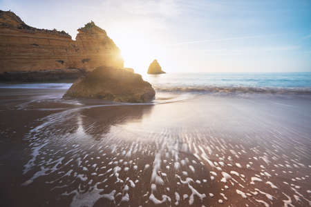 Sea Waves at Praia Dona Ana Beach with beautiful Rock formations at sunrise - Long Exposure shot - Lagos, Algarve, Portugalの写真素材