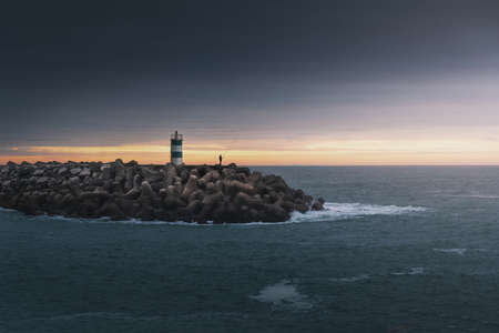 Fisherman near the lighthouse at Nazare Pontao - Nazare, Portugalの写真素材