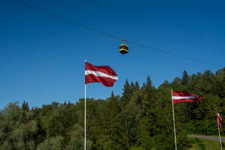 Latvian National Flags and yellow Sigulda Cable Car - Sigulda, Latviaの写真素材