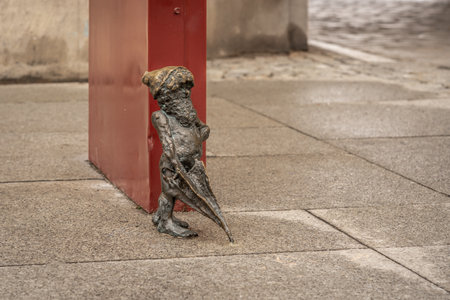 Wroclaw, Poland - Aug 21, 2019: Swordsman dwarf naked with an umbrella (Szermierz) - since 2005 hundreds of wroclaw dwarf figurines appeared in the city - Wroclaw, Polandのeditorial素材
