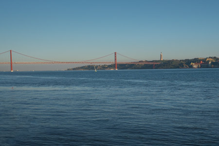 Tagus River (Rio Tejo) with 25 de Abril Bridge and Sanctuary of Christ the King on background -...