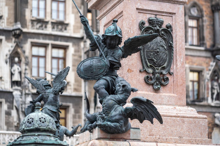 Munich, Germany - Oct 30, 2019: Putto fighting a dragon representing hunger or famine - Mariensaule Sculpture at Marienplatz Square - Munich, Bavaria, Germanyのeditorial素材