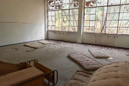 Old abandoned and decay mattresses bed in abandoned building room in Italy house in the wood with windows and forest outsideの写真素材