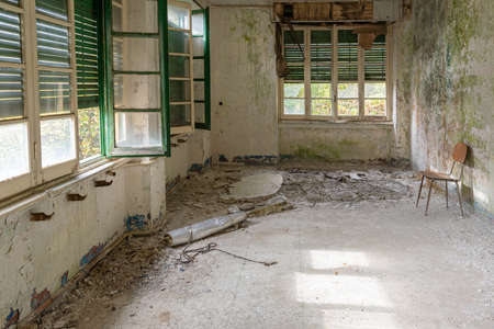 Old abandoned building room in the wood with windows and a chairの写真素材