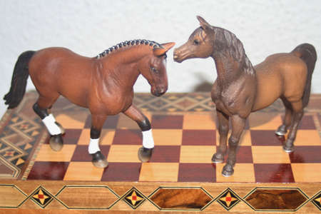Toy horses on a chess boardの写真素材