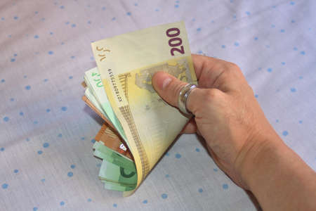 Hand holding money in times of economic crisisの写真素材