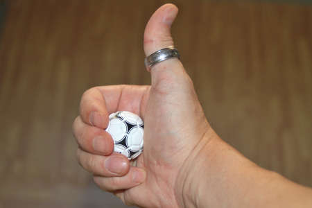 Man's hand with a small toy soccer ballの写真素材