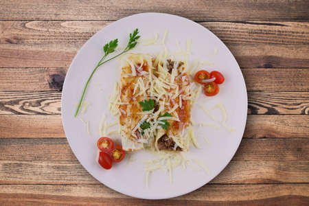 Pancakes with meat, in tomato sauce and cheese, with cilantro and grated cheese on top, and some...
