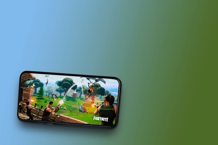 Fortnite game app on the smartphone screen on blue and green background. Top view. Rio de Janeiro,...