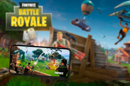 Fortnite game app on the smartphone screen with the game screen blurred in the background. Rio de Janeiro, RJ, Brazil. May 2021.のeditorial素材