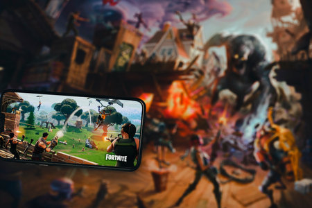 Fortnite game app on the smartphone screen with the game screen blurred in the background. Rio de Janeiro, RJ, Brazil. May 2021.のeditorial素材