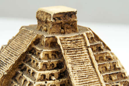 Macro closeup of mini pyramid isolated on white background. Found in Tulum, Mexico. Selective focus.