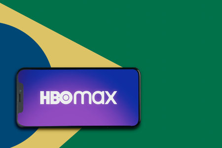 Hbo Max app on the smartphone screen with the colors of the Brazilian flag in the background. App for movies and TV series via streaming. Rio de Janeiro, RJ, Brazil. May 2021.のeditorial素材