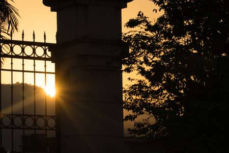 Beautiful sunset in Barra da Tijuca in Rio de Janeiro, Brazil. Hill, trees, and buildings. Against light.の写真素材