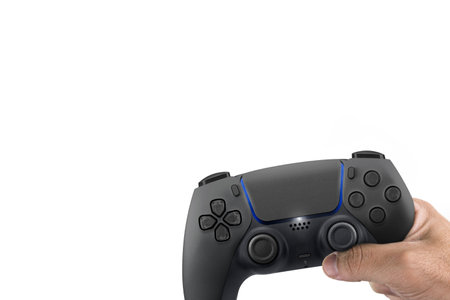 Male hand holding a Next Generation black game controller isolated on white background.