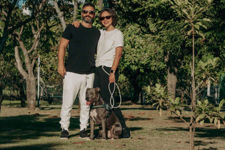 Brazilian family formed by man, woman and a pit bull dog in the public park. Affection and love relationship between humans and animals.の写真素材