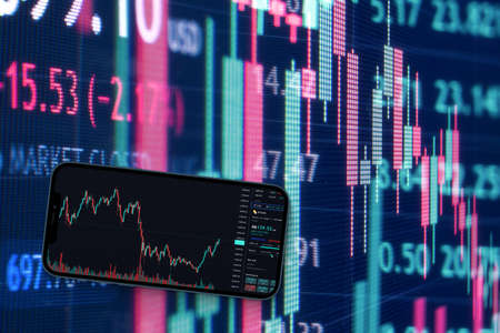 A smartphone with financial stock market graph. Stock Exchange. Graphics in the background.