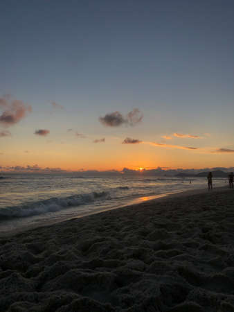 Sunset at Barra da Tijuca beach in Rio de Janeiro, Brazil. Sea with calm waves.