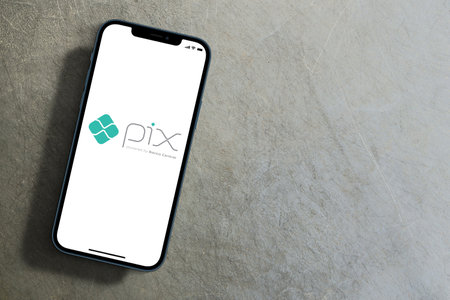 Pix logo app on smartphone screen with large shadow marked giving the feeling that you are taller on cement background. Rio de Janeiro, RJ, Brazil. September 2021.のeditorial素材