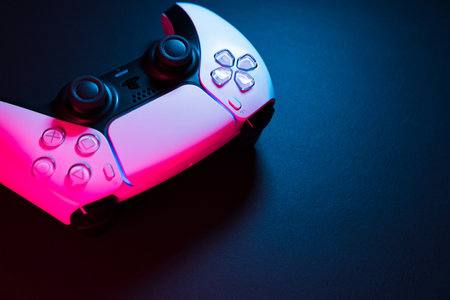 Macro close-up of Playstation 5 Dual Sense controller isolated on black background with colored lights illuminating it. Selective focus and low light. Rio de Janeiro, RJ, Brazil. September 2021.のeditorial素材