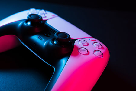 Macro close-up of Playstation 5 Dual Sense controller isolated on black background with colored...