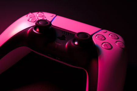 Macro close-up of Playstation 5 Dual Sense controller isolated on black background with colored lights illuminating it. Selective focus and low light. Rio de Janeiro, RJ, Brazil. September 2021.のeditorial素材