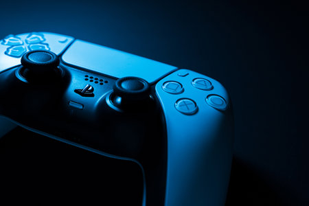 Macro close-up of Playstation 5 Dual Sense controller isolated on black background with colored...