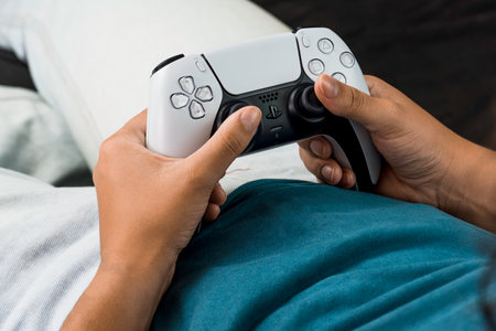 Girl holding a Playstation 5 Dual Sense Controller while playing the game. Rio de Janeiro, RJ,...
