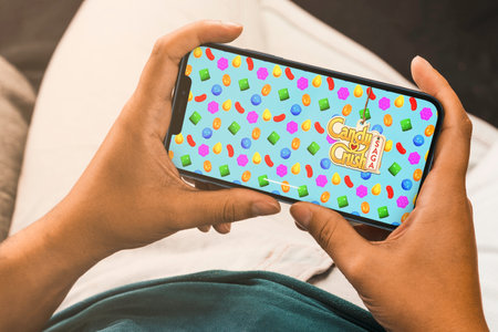 Female hand holding a smartphone with Candy Crush Saga mobile game app on the screen. Rio de Janeiro, RJ, Brazil. September 2021.のeditorial素材