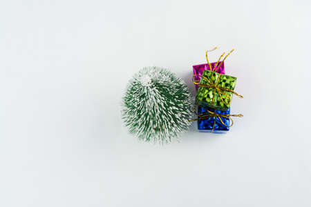 Christmas ornament isolated on white background. Mini Christmas tree with some small gift boxes on the side to celebrate the arrival of Santa Claus. Top view.の写真素材