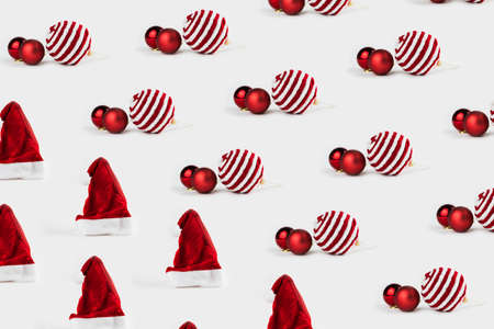 Pattern with Christmas ornaments including balls and Santa's cap on white background.の写真素材