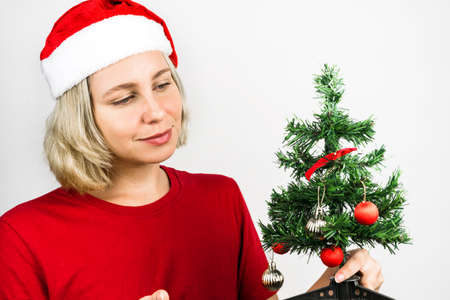 Young beautiful girl with Santa Claus accessories such as Santa's Cap and red outfit isolated on...