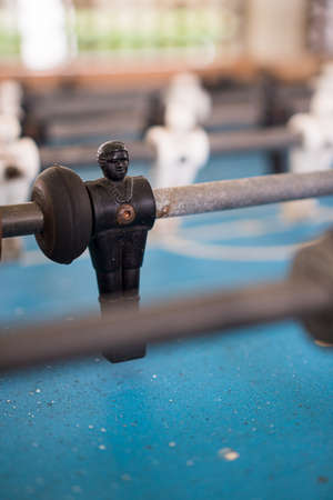Foosball game, also known as Toto. Black and white players on the blue field. Selective focus....
