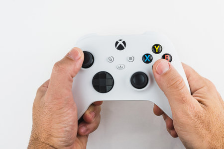 Man holding Xbox Series S white controller isolated on white background. Selective focus. Rio de Janeiro, RJ, Brazil. November 2021.のeditorial素材