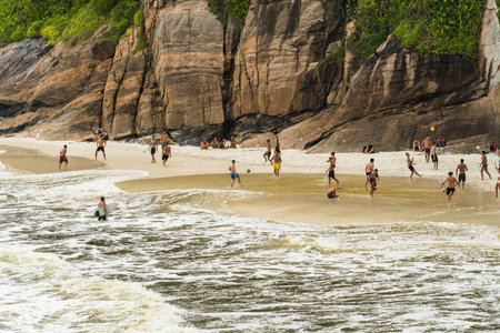 People playing "Altinha" with the soccer ball on Joatinga beach, Rio de Janeiro, Brazil. Day with blue sky and some clouds. Rio de Janeiro, Brazil. November 2021のeditorial素材