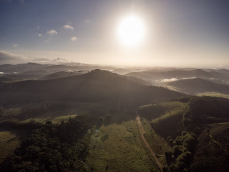 Aerial view of beautiful forest full of nature and pasture fields in TremembÃ© in Vale da ParaÃ­ba in SÃ£o Paulo. Mountains and hills in sunny day. Lots of green and tropical vegetation. Drone. Sunset.の写真素材